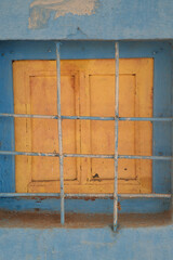 closed wooden shutters behind the grille
