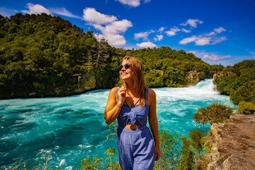 young woman in sunglasses in front of a waterfallw