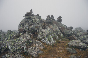 Stone pyramids on the mountain in the fog