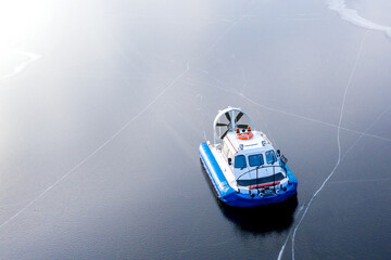 Hovercraft on the icy surface of the reservoir. The ice is covered with numerous cracks. Shooting...