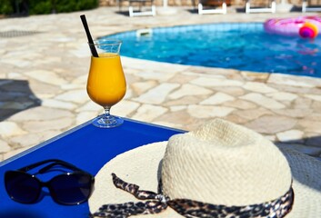 Orange cocktail on poolside outdoor in summer