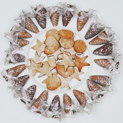 Sweet Xmas star and heart shape cookies with decorated pine cones on the white background