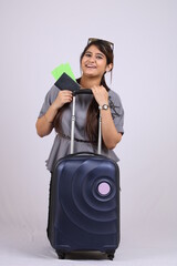 Beautiful smiling young Indian woman tourist holding passport and boarding pass isolated on white background.