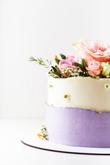 White and violet wedding cake decorated with flowers on the white background