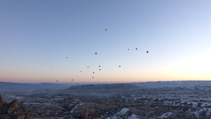 Hot Air Balloons rising in the sky during sunrise in Cappadocia in Göreme, Turkey.