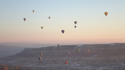 Hot Air Balloons rising in the sky during sunrise in Cappadocia in Göreme, Turkey.