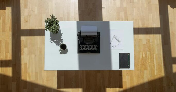 Timelapse top view shot of a desk with typewriter moving shadows passing by shot in 4k