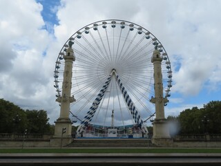 beautiful metallic Ferris wheel surrounded by large and tall statues