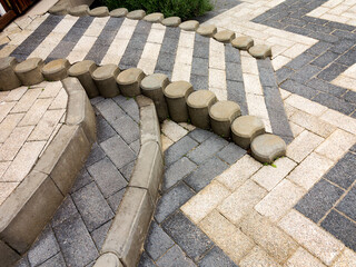 Close-up paving slabs by mosaic. Road paving, construction. Tessellated sidewalk tile. Colored concrete paving slab.