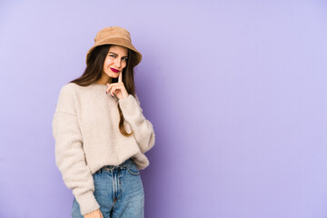 Young caucasian woman isolated on purple background contemplating, planning a strategy, thinking about the way of a business.