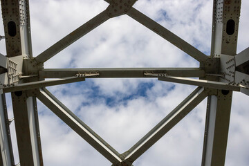 Close-up of an arched farm span of posts and crossbars, rivets on the planes