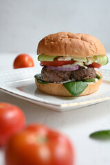Milanese burger, with tomatoes, lettuce and french fries, in white background