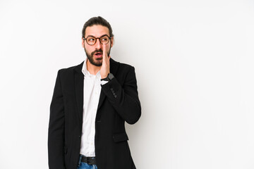 Young caucasian business man isolated on a white background is saying a secret hot braking news and looking aside