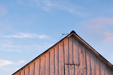  the roof of a rustic barn at sunset against the backdrop of a beautiful sky