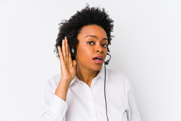 Young african american telemarketer woman isolated trying to listening a gossip.