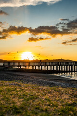 Fototapeta premium Woman on a pier at sunset
