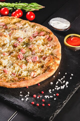Traditional Italian focaccia among tomato and spices on a dark background, studio light. Traditional food concept