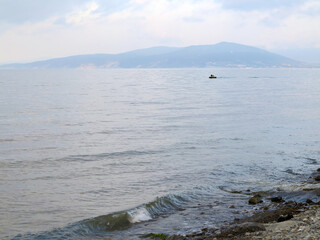 In fog disappears fantastic beautiful sea landscape with view of horizon of silhouette of urban buildings and high-rise buildings off coast of Novorossiysk, Russia. Minimalism. Image shows good grain 