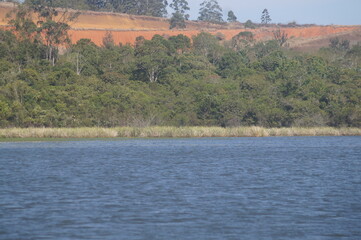 as &aacute;guas de um belo e calmo lago azul com uma floresta ao fundo