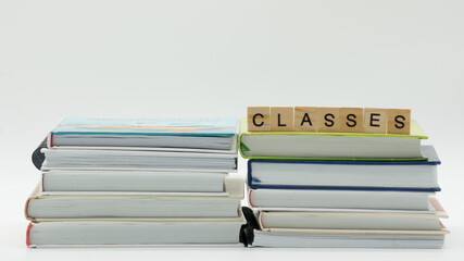 Classes words written on wood block. Classes text on books on white background. Distance learning