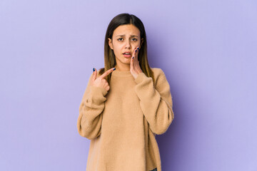 Young woman isolated on purple background having a strong teeth pain, molar ache.