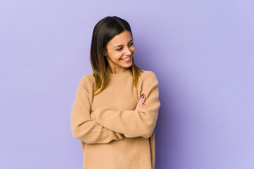 Young woman isolated on purple background smiling confident with crossed arms.