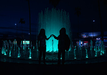 hermanos en fuente haciendo un corazón con las manos 