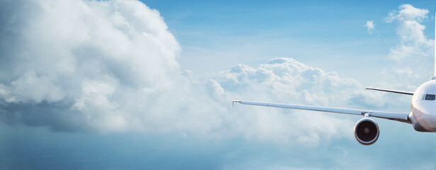Commercial airplane jetliner flying above dramatic clouds in beautiful light. Travel concept. - obrazy, fototapety, plakaty