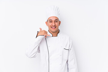 Young latin chef man isolated showing a mobile phone call gesture with fingers.