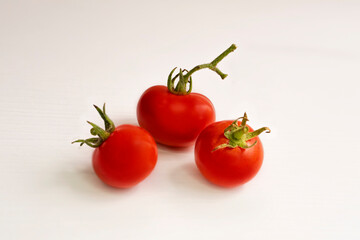 Cherry tomatoes. Small red tomatoes on a white background. Close-up. Tomatoes with herbs. Green sprigs of dill