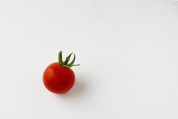 Cherry tomatoes. Small red tomatoes on a white background. Close-up. Tomatoes with herbs. Green sprigs of dill