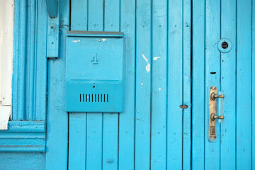 Mailbox on the door of an old house.