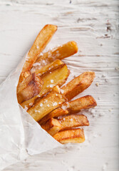 Tasty french fries on vintage wooden table, close-up