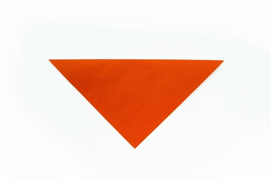 Step-by-step origami instructions. How to make a dog out of orange colored paper. Instructions on a white background top view. Step 1-7.