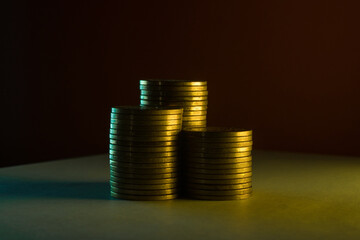 Stacks of gold coins in the dark light.