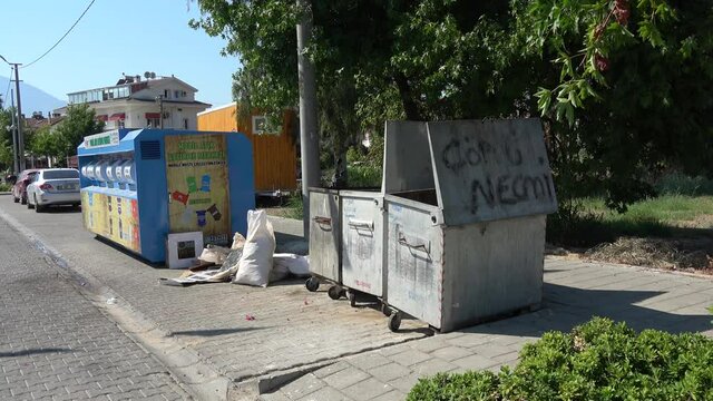 Fethiye, Turkey - 29th of August 2020: 4K Old dirty waste containers near new mobile recycling carriage
