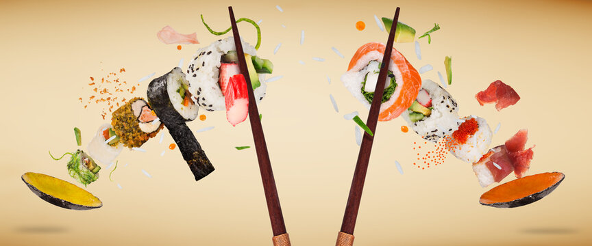 Pieces of delicious japanese sushi frozen in the air on pastel color background.