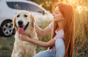 Portrait of teenage girl petting golden retriever