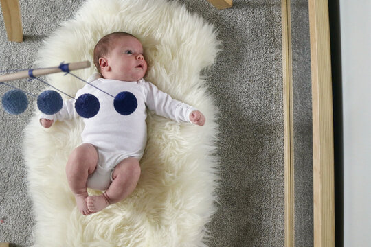 baby looking in mirror with montessori mobile overhead