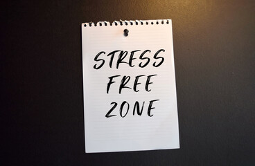 Paper note with STRESS FREE ZONE written on black slate board