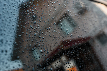 Reflection of a house in a blue glass with raindrops.