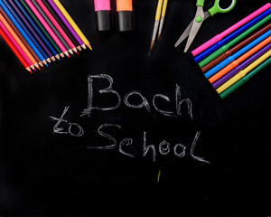 School supplies on a blackboard with back to school inscription.