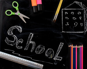 School supplies on a blackboard with school inscriptio