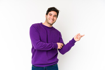 Young man isolated on white background smiling cheerfully pointing with forefinger away.