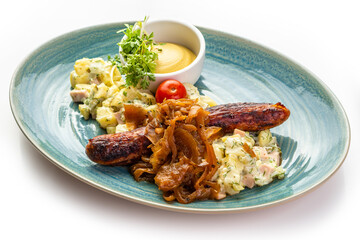 Fried German sausage, mustard and salad on a blue plate