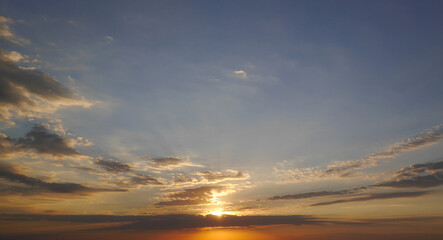 Sunrise sky and sun through the clouds over. Golden sunrise with blue colors.