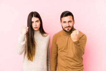 Fototapeta premium Young caucasian couple isolated showing fist to camera, aggressive facial expression.