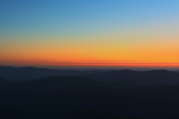 The first or last rays of the sun on a mountain pass. Morning and evening in nature. Colorful sunset and sunrise over the mountain hills. Carpathians in summer and autumn.