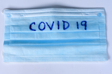 Coronavirus Text On A Blue Surgical Mask Laying On A White Background