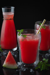 Summer cold drink with watermelon and mint on a black wooden background. Copy space